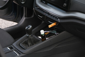 Installation of a clothespin on a car interior vent, impregnated with essential oil. To detoxify and remove unpleasant odours.