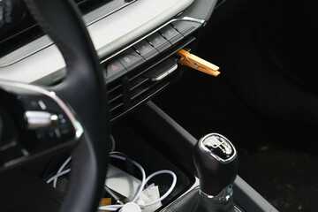 Installation of a clothespin on a car interior vent, impregnated with essential oil. To detoxify and remove unpleasant odours.