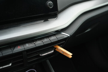Installation of a clothespin on a car interior vent, impregnated with essential oil. To detoxify and remove unpleasant odours.