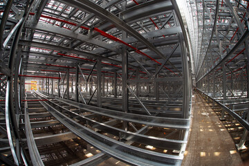 Fish-eye view of steel galvanised framework of rack-supported structure of asrs warehouse with sprinkler system piping and reflection in rainwater pond