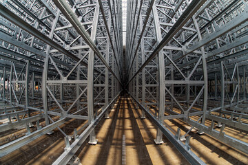 Fish-eye view of steel galvanised framework clad rack structure of asrs warehouse with sprinkler system piping and reflections in rainwater pond
