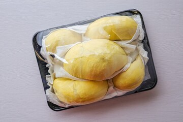 Fresh Durian in black plastic pack on white background, fruit	