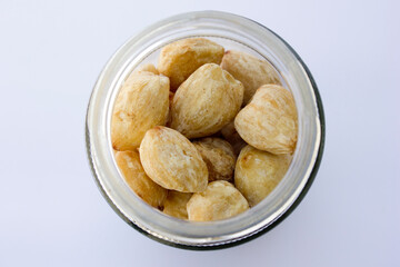 Candlenut seeds in a glass jar. Candlenuts are rich in fiber, which helps facilitate the digestive process and promotes regular bowel movements. 