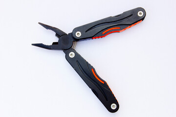 A black multifunctional pliers. It features several additional tools such as a knife, small saw,...