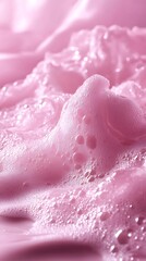 Close-up of soft pink foam bubbles with a smooth texture and a light pink background.