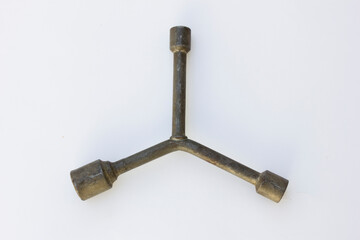 A three-way lug wrench, also known as a tire iron or a cross wrench. This tool is used for loosening and tightening lug nuts on the wheels of vehicles.