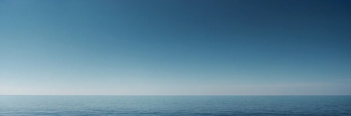 Obraz premium A minimalist ocean scene with a seamless gradient sky and faint horizon. The serene blue tones and calm water evoke tranquility and openness, ideal for themes of peace, calm, and vast open spaces.