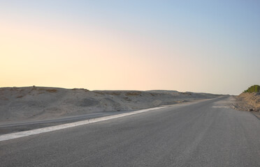 Empty desert road at sunset, front focus on asphalt, Egypt.
