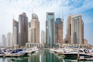 Dubai Marina district with skyscrapers, cruise boats, yachts and promenade, United Arab Emirates. High quality photo