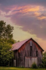Obraz premium Rustic Barn Surrounded by Lush Greenery at Sunset