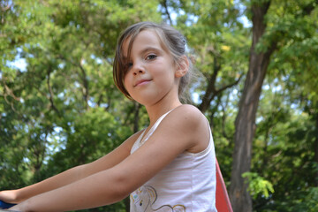 Cute kid girl 10 year old posing on nature background. Looking at camera. Childhood.Blonde girl...