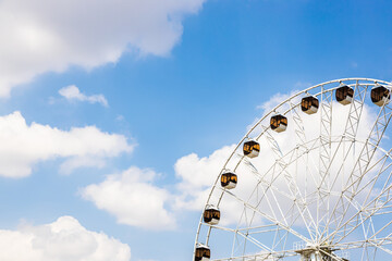 observation wheel and blue sky with white clouds