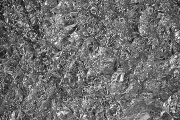 Processed collage of shiny metal silver gray foil crumpled packaging material texture
