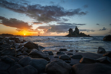 Tenerife, June 2022: Waves rolliing into shore around volcanic rocks at sunset