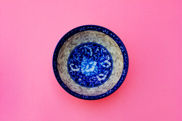 A blue floral ceramic bowl and two wooden chopsticks. This photo was taken from above.