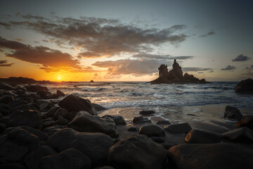 Tenerife, June 2022: Waves rolliing into shore around volcanic rocks at sunset