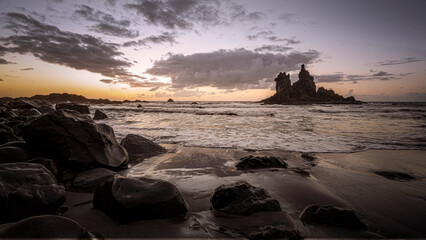 Tenerife, June 2022: Waves rolliing into shore around volcanic rocks at sunset