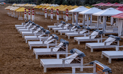 Rows of sun loungers on the beach on a summer day.