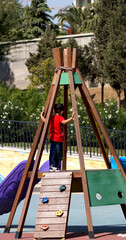 Kid playing on the playground on a summer day . High quality photo