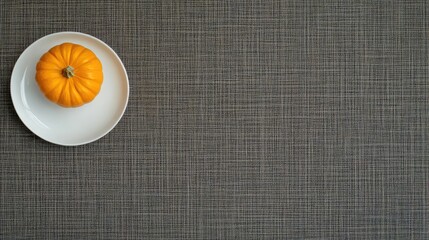 A charming table setting features a small white pumpkin and acorns on a plate, accompanied by a linen napkin atop a burlap runner, perfect for autumn gatherings