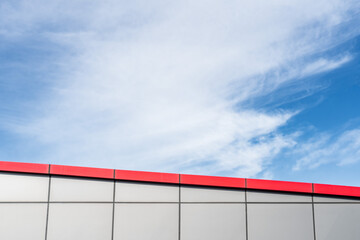 Cloudy Sky Above Modern Red and Silver Urban Rooftop Architecture: Minimalism and Negative Space