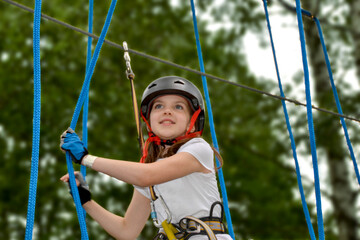 adventure climbing high wire park - people on course in mountain helmet and safety equipment. High...