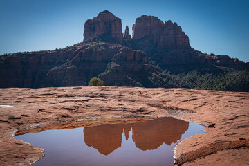 Breathtaking view of Cathedral Rock in Sedona, Arizona, perfectly reflected in a serene pool of...