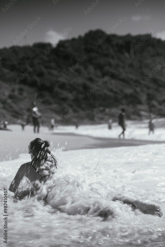 Wall mural Beach Bliss A Woman Enjoying the Waves in Black and White Photography by the Shore