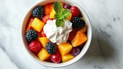 Top view of a dessert bowl filled with colorful fruit salad, topped with a dollop of whipped cream and a sprig of mint.