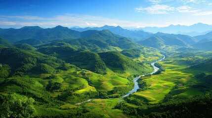 Obraz premium Top view of a lush green mountain range, with a winding river and a patchwork of fields below, under a clear blue sky.