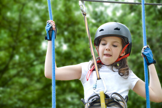 adventure climbing high wire park - people on course in mountain helmet and safety equipment. High quality photo. High quality photo