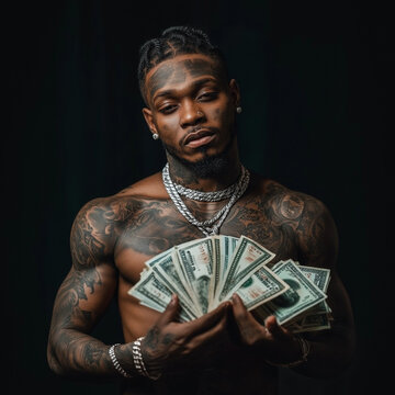 Tattooed North African rapper holding big banknotes. Black background, bare chest, wealth, showing off money.