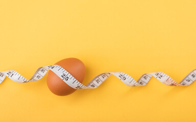 Fresh egg and measuring tape on a table symbolize the idea of eating eggs for weight loss or health. The image highlights eggs as a nutritious choice for a balanced diet and fitness goals