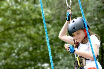 adventure climbing high wire park - people on course in mountain helmet and safety equipment. High quality photo. High quality photo
