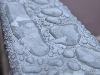 Water drops on a metal surface close view, raindrops on a fence