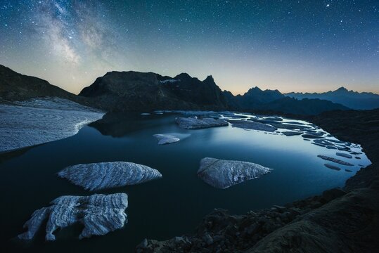 Nightscape view of icebergs floating on a mountain lake with the milky way above
