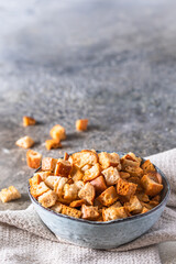 HomeBowl with homemade crispy croutons for salad or soups on gray background, vertical with copy space