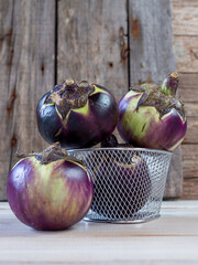 berenjena redonda o berenjena de florencia. Melanzana di firenze sobre fondo r&uacute;stico