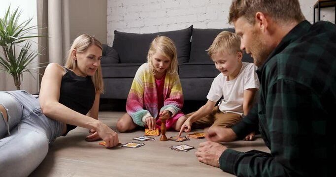 family with kids playing board game at home on the floor. bonding activities