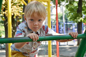 Little children run around and play in the playground. Game center for a young child. Little girl...