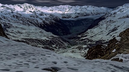   A stunning snow-topped mountain range viewed from atop a snow-capped peak, showcasing footprints in the fresh snow