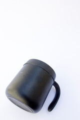 Sleek Black Travel Mug: A minimalist design featuring a matte black travel mug with a handle and lid. Ideal for marketing campaigns, this image highlights the mug’s modern aesthetic.