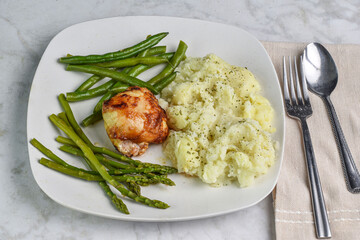  barbecue chicken thigh with asparagus and green  beans.