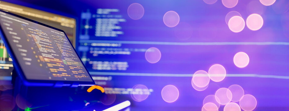 Programmer manually working with program code on a computer at night in a data center and technology concept.