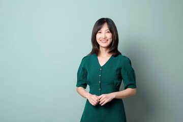 Asian woman wearing green dresses isolated on green background