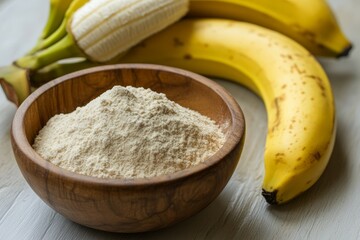 Banana flour in a wooden bowl on a solid white background, close-up detail