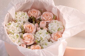Zephyr bouquet of Flowers in a pink box on a light background, holiday concept.