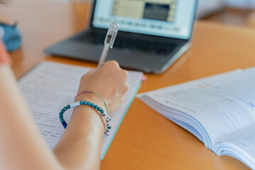 Girl studies and does homework at desk at home