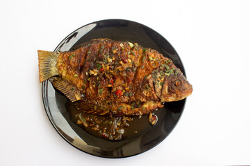 Soy Sauce Glazed Gouramy Fish: A stunning image of a fried gouramy fish smothered in a rich soy sauce glaze, suitable for use in food and lifestyle publications, cookbooks, and recipe websites.