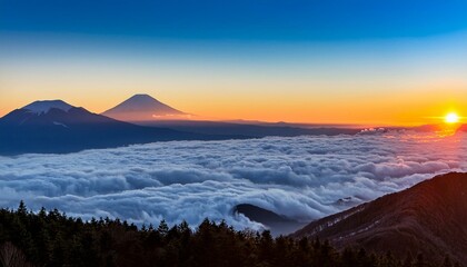Fototapeta premium 日の出の光に照らされた富士山の頂が、広がる雲海の上にぽっかりと現れる。雲の海が幻想的で、まるで空中に広がるかのような光景